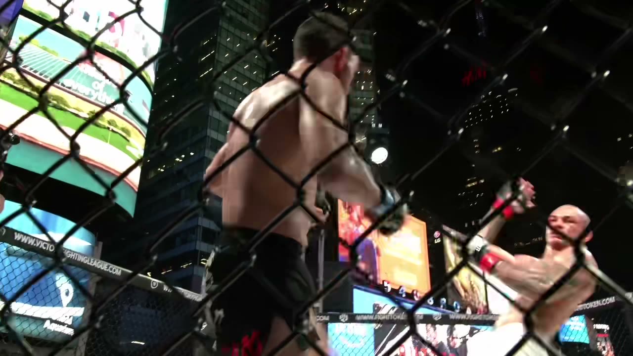A fighter in the cage in Times Square at night